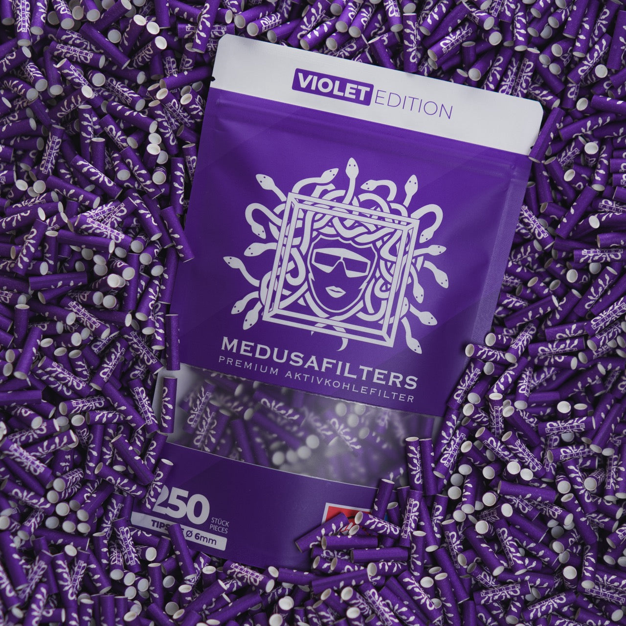 Medusafilters Premium Aktivkohlefilter mit Kokosnuss-Aktivkohle und veganen Fasercaps 250er Packung VIOLET Edition Tip Size 6 mm in Filter liegend 
