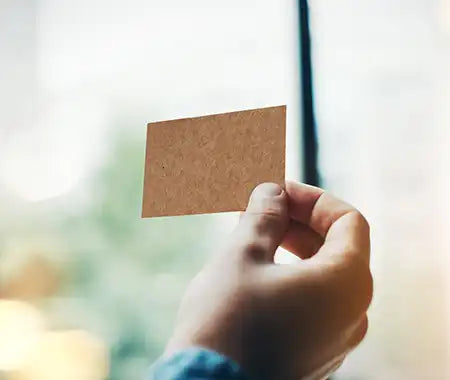 Hand hält ein Stück Pappe